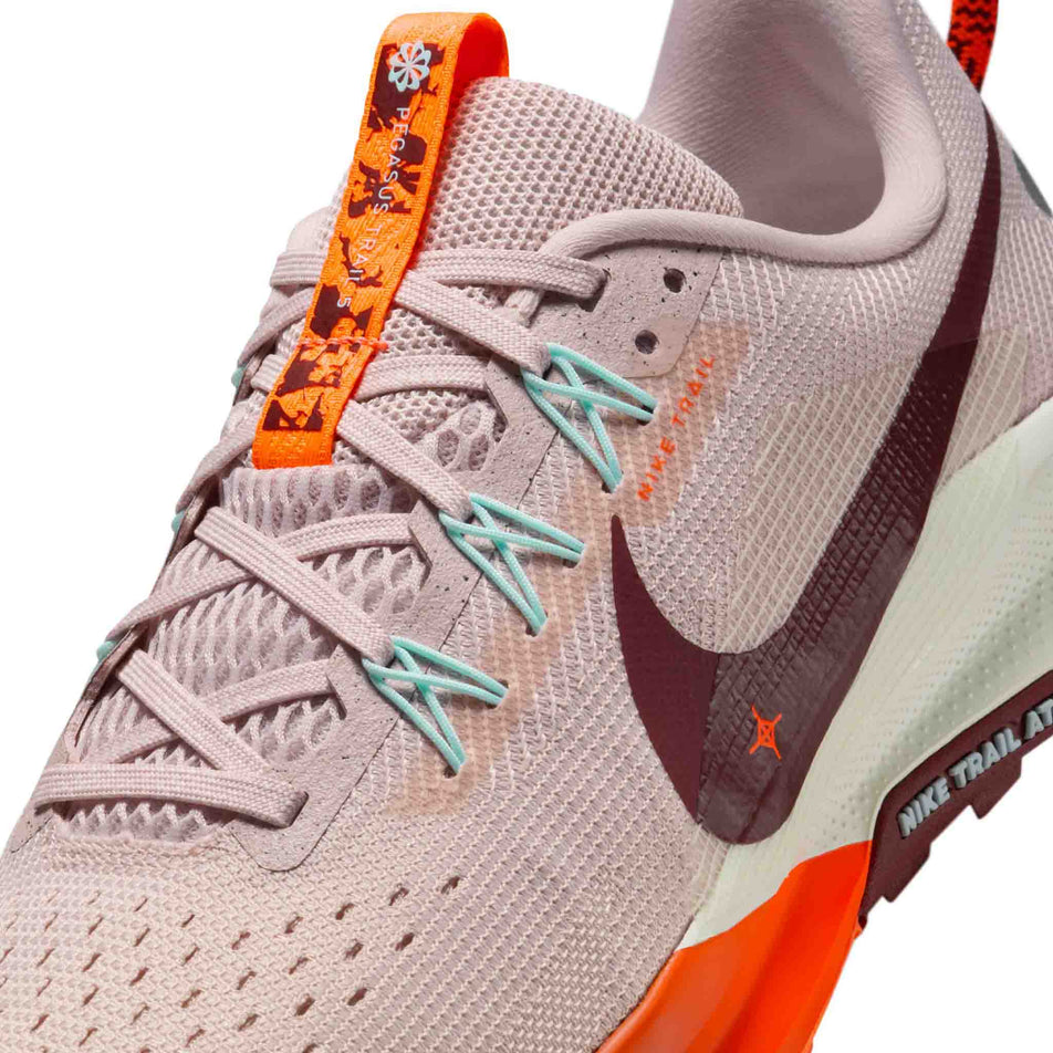 Close up of the upper of the left shoe from a pair of Nike Women's Pegasus Trail 5 Running Shoes in the Silt Red/Dark Team Red-Hyper Crimson colourway. (8686796079266)