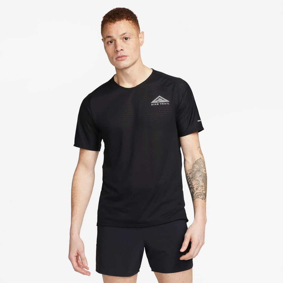 Front view of a model wearing a Nike Men's Trail Solar Chase Dri-FIT Short-Sleeve Running Top in the Black/White colourway. Model is also wearing a pair of Nike shorts. (8140170199202)