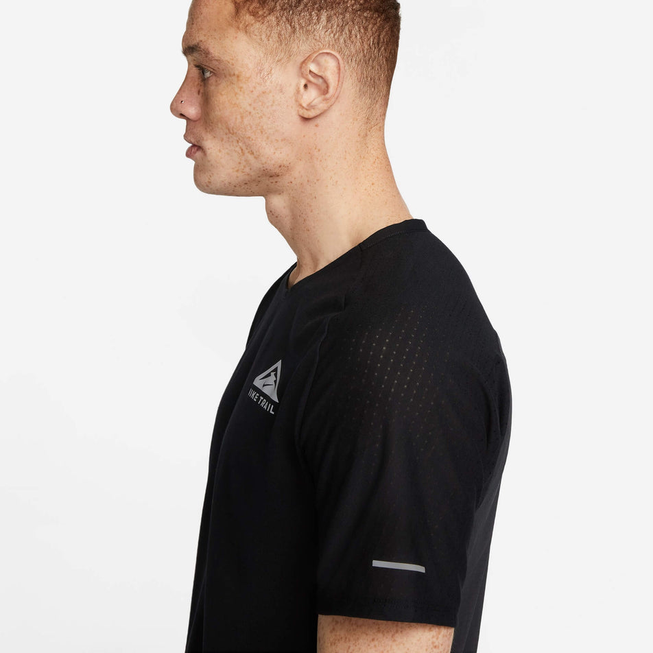 Left-side view of the upper third of a Nike Men's Trail Solar Chase Dri-FIT Short-Sleeve Running Top in the Black/White colourway. Top is being worn by a model. (8140170199202)