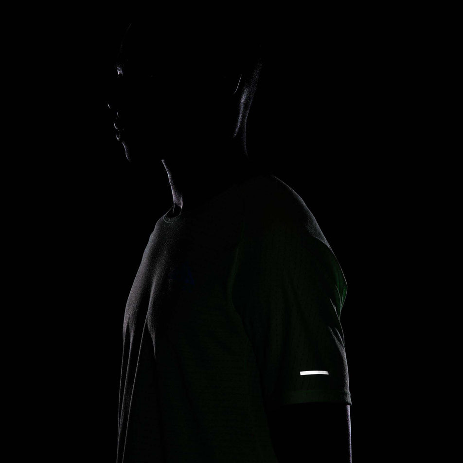 The reflective detail on the outside of the left sleeve of a Nike Men's Trail Solar Chase Dri-FIT Short-Sleeve Running Top in the Vapor Green/Black colourway. (8215882825890)