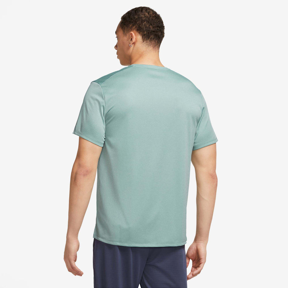 Back view of a model wearing a Nike Men's Miler Dri-FIT UV Short-Sleeve Running Top in the Mineral/Jade Ice/HTR/Reflective Silv colourway (7980005261474)