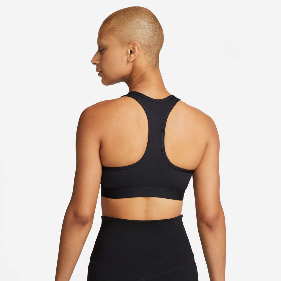 Back view of a model wearing a Nike  Women's Swoosh Medium Support Padded Sports Bra in the Black/White colourway (8140167086242)
