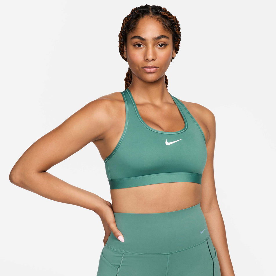 Front view of a model wearing a Nike Women's Swoosh Medium Support Padded Sports Bra in the Bicoastal/White colourway. Model is also wearing Nike leggings. (8299354063010)