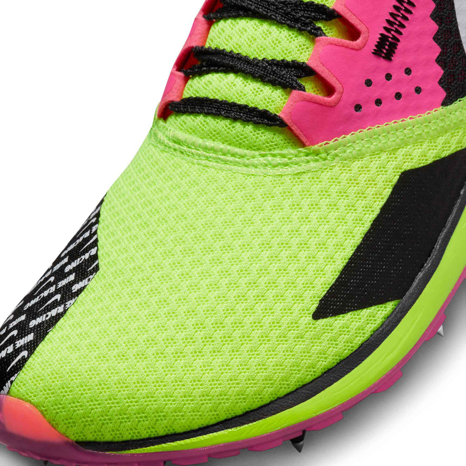 Lateral side of the toe box on the left shoe from a pair of Nike Unisex Rival XC 6 Cross-Country Spikes in the Volt/White-Black-Hyper Pink colourway (8064173211810)