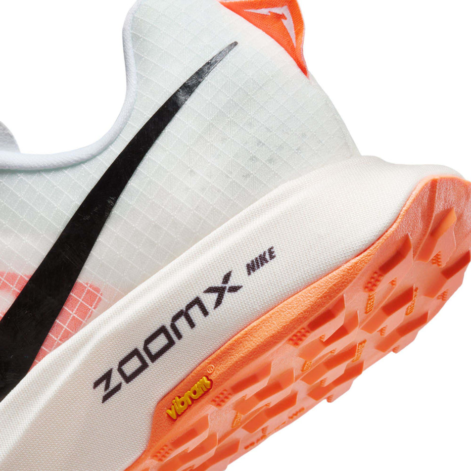 Lateral side of the back of the left shoe from a pair of Nike Women's Ultrafly Trail Running Shoes in the White/Black-Total Orange-Pale Ivory colourway  (7995936637090)