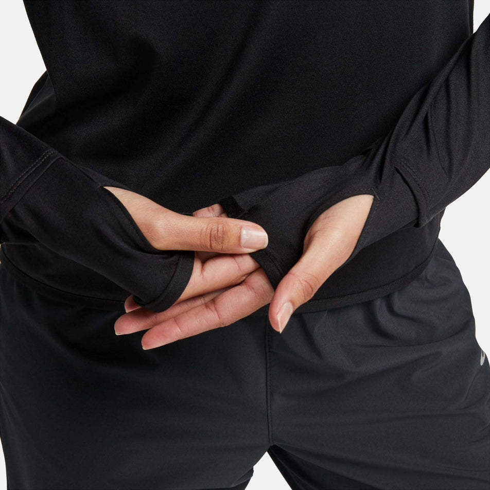 A model demonstrating the thumb loops on a Nike Women's Dri-FIT Swift Element UV 1/4-Zip Running Top in the Black/Reflective Silv colourway (8049594007714)