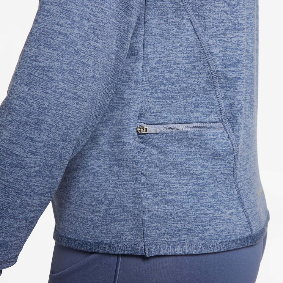 The zipped pocket on the lower left side of a Nike Women's Dri-FIT Swift Element UV 1/4-Zip Running Top in the Ashen Slate/Reflective Silv colourway (8059808710818)