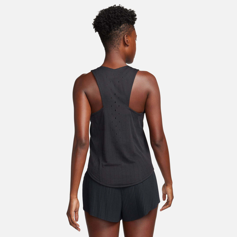 Back view of a model wearing a Nike Women's AeroSwift Dri-FIT ADV Running Singlet in the Black/White colourway. Model is also wearing Nike shorts. (8185995428002)