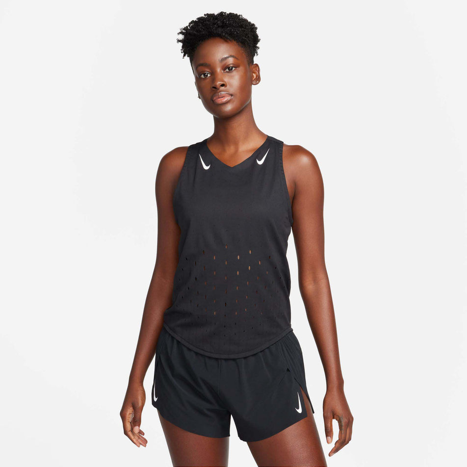 Front view of a model wearing a Nike Women's AeroSwift Dri-FIT ADV Running Singlet in the Black/White colourway. Model is also wearing Nike shorts. (8185995428002)