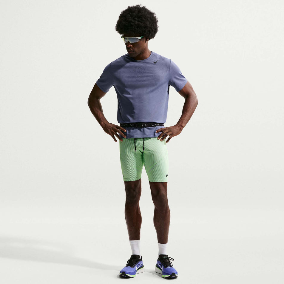 Front view of a model wearing the Nike Men's AeroSwift Dri-FIT ADV Running 1/2-Length Tights in the Lime Blast/Steam/Light Silver/Black colourway.