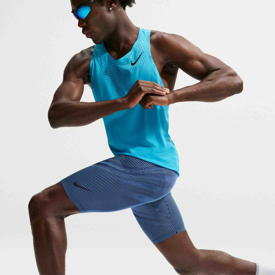 Angled view of a model wearing the Nike Men's AeroSwift Dri-FIT ADV Running 1/2-Length Tights in the Baltic Blue/Black/Old Royal Black colourway.