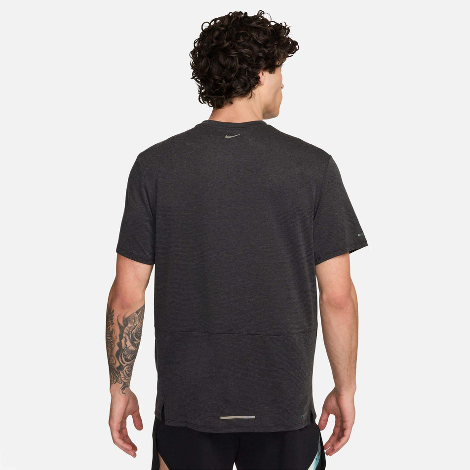 Back view of a model wearing a Nike Men's Rise 365 Running Division Dri-FIT Running Top in the Black/Black/Summit White colourway. Model is also wearing Nike shorts. (8215874371746)