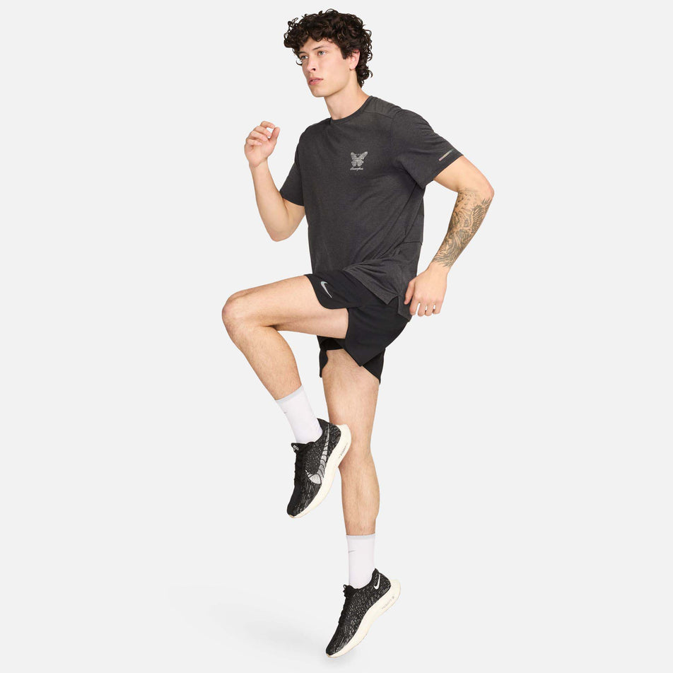 Front view of a model wearing a Nike Men's Rise 365 Running Division Dri-FIT Running Top in the Black/Black/Summit White colourway. Model is in a running pose and is also wearing Nike shorts, shoes and socks. (8215874371746)