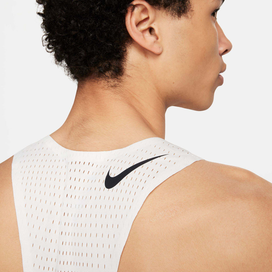 Close-up back view of a model wearing a Nike Men's AeroSwift Dri-FIT ADV Running Singlet in the Summit White/Black colourway. Only the upper section of the singlet can be seen in the image. (8186007322786)