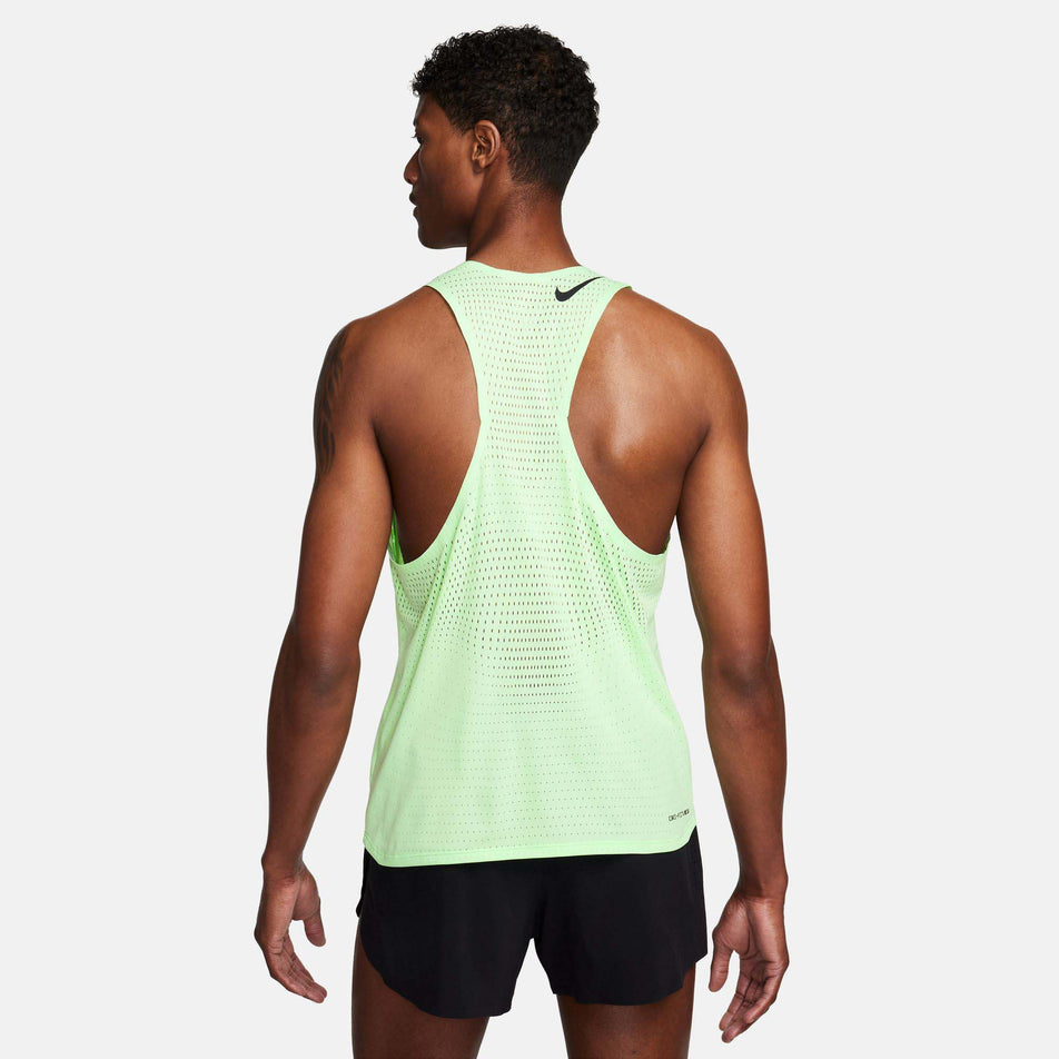 Back view of a model wearing a Nike Men's AeroSwift Dri-FIT ADV Running Singlet in the Vapor Green/Black colourway. Model is also wearing Nike shorts. (8186010337442)