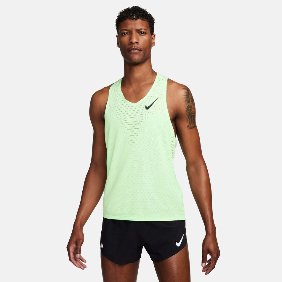 Front view of a model wearing a Nike Men's AeroSwift Dri-FIT ADV Running Singlet in the Vapor Green/Black colourway. Model is also wearing Nike shorts.  (8186010337442)