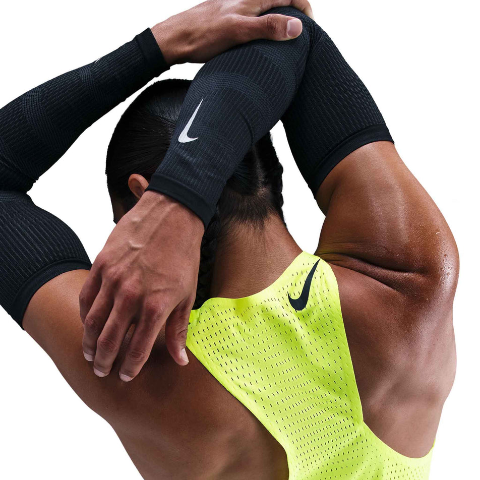 Back view of a model wearing the Nike Men's AeroSwift Dri-FIT ADV Running Singlet in the Volt/Black colourway. (8778164699298)