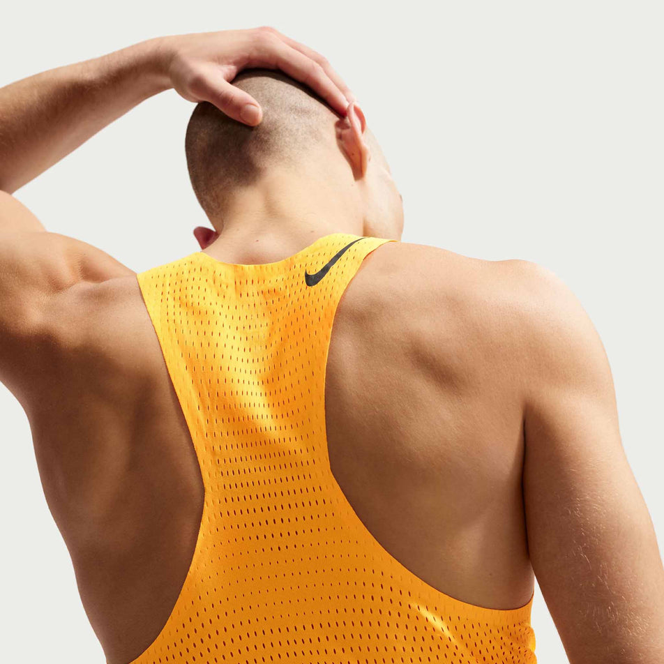 Back view of a model wearing the Nike Men's AeroSwift Dri-FIT ADV Running Singlet in the Laser Orange/Black colourway.