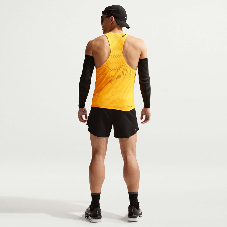 Back view of a model wearing the Nike Men's AeroSwift Dri-FIT ADV Running Singlet in the Laser Orange/Black colourway.