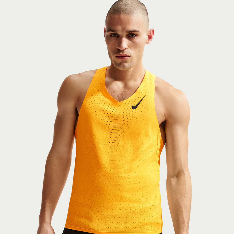 Front view of a model wearing the Nike Men's AeroSwift Dri-FIT ADV Running Singlet in the Laser Orange/Black colourway.