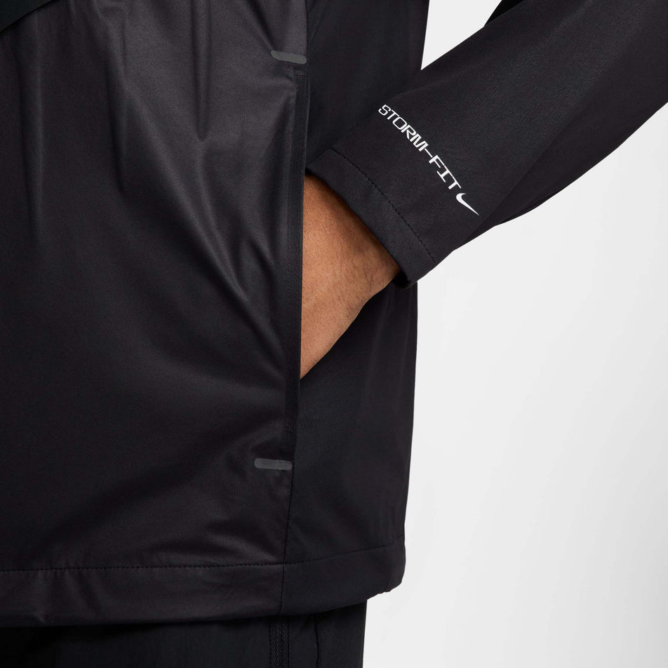 The side pocket of the Nike Men's AeroSwift Storm-FIT Aerogami Running Jacket in the Black/Summit White colourway.