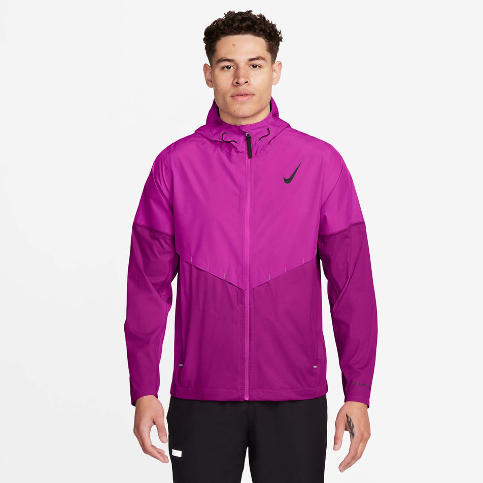 The front view of a model wearing the Nike Storm-FIT Aeroswift Aerogami Running Jacket in the Vivid Grape/Black colourway. Model is also wearing Nike trousers. (8497739333794)