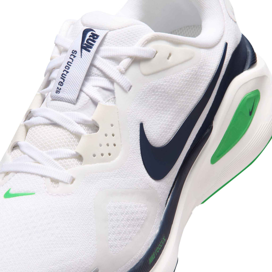Close-up view of the upper of the left shoe from a pair of Nike Men's Structure 26 Road Running Shoes in the White/Midnight Navy-Green Spark colourway.