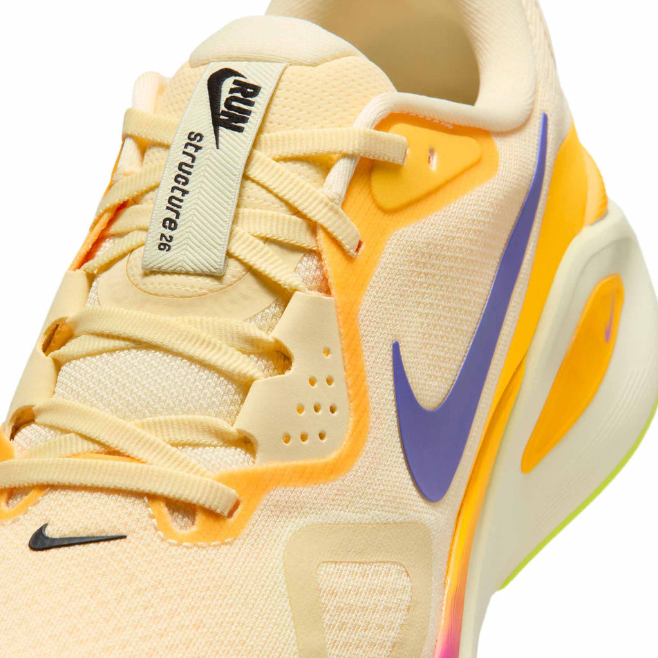 Close-up view of the upper of the left shoe from a pair of Nike Men's Structure 26 Road Running Shoes in the Alabaster/Indigo Burst-Hyper Violet colourway.