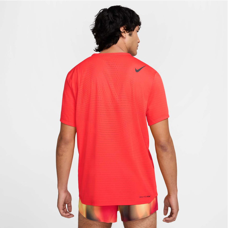 Back view of a model wearing the Nike Men's AeroSwift Dri-FIT ADV Short-Sleeve Running Top in the Light Crimson/Black colourway.  (8560409706658)