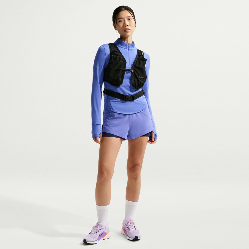 Front view of a model wearing the Nike Women's Swift Dri-FIT Mid-Rise 2-in-1 Running Shorts in the Sapphire/Midnight Navy/Reflective Silver colourway.