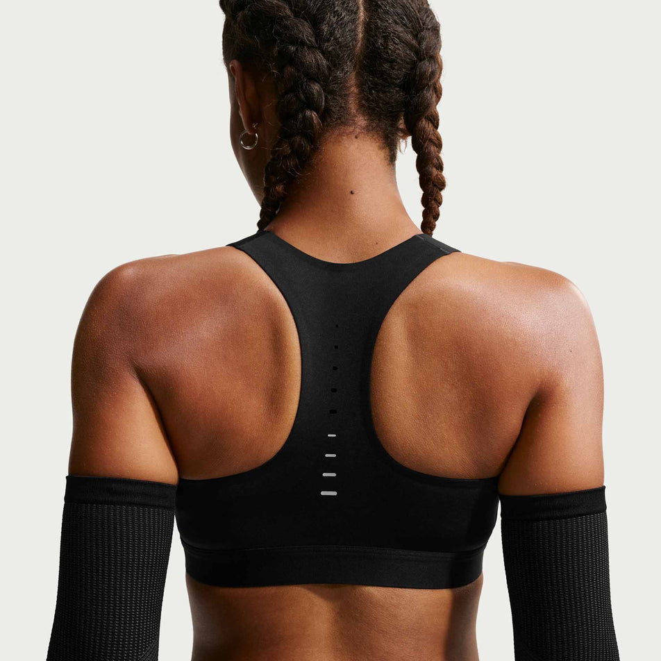 Back view of a model wearing the Nike Women's Swift High-Support Lightly Lined Sports Bra in the Black/Silver colourway.