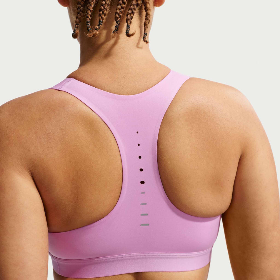 Back view of a model wearing the Nike Women's Swift High-Support Lightly Lined Sports Bra in the Light Magenta/Reflective Silver colourway.