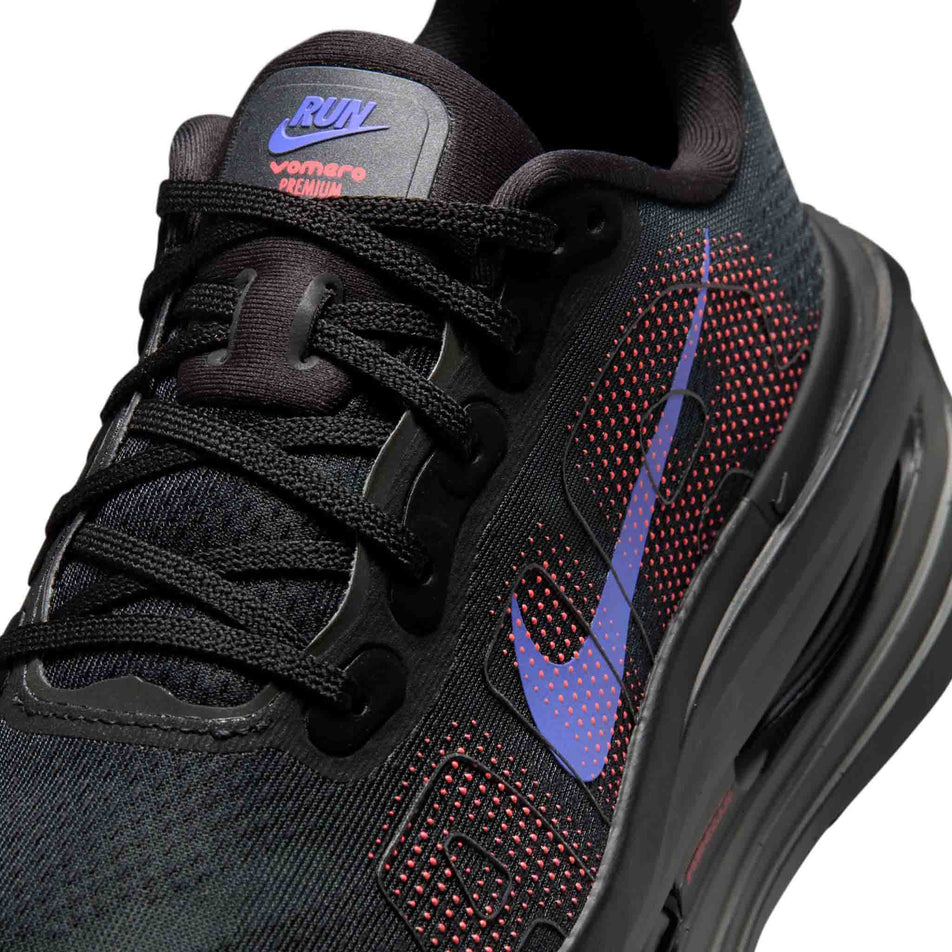 Close-up view of the upper of the left shoe from a pair of Nike Women's Vomero Premium Road Running Shoes in the Black/Sapphire-Hot Lava-Anthracite colourway.