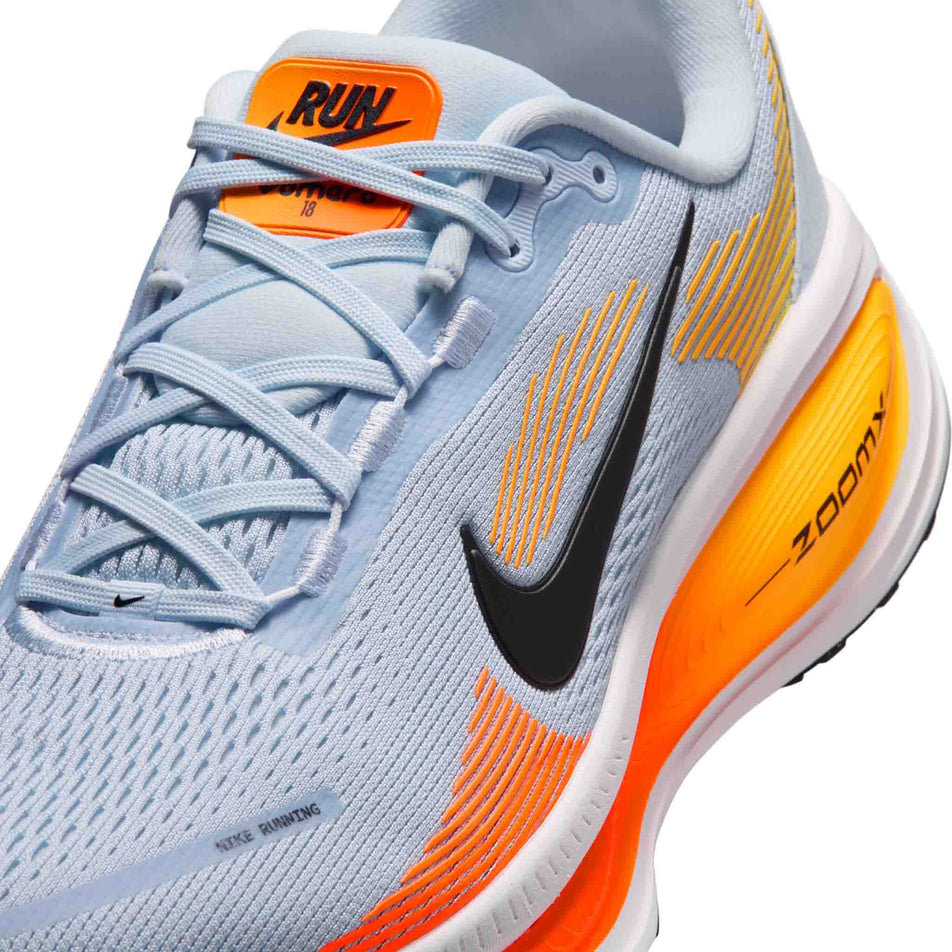 Close-up view of the upper of the left shoe from a pair of Nike Men's Vomero 18 Road Running Shoes in the Hydrogen Blue/Black-Laser Orange colourway.