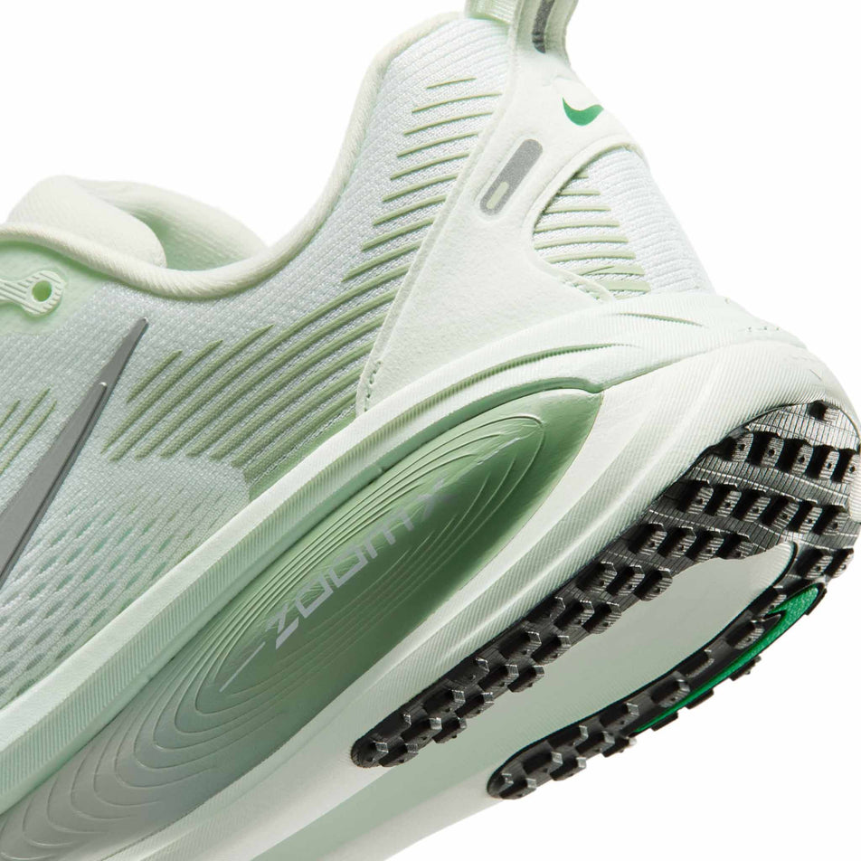 Close-up view of the rearfoot section of the left shoe from a pair of Nike Women's Vomero 18 Road Running Shoes in the Barely Green/Metallic Silver-Steam colourway. 