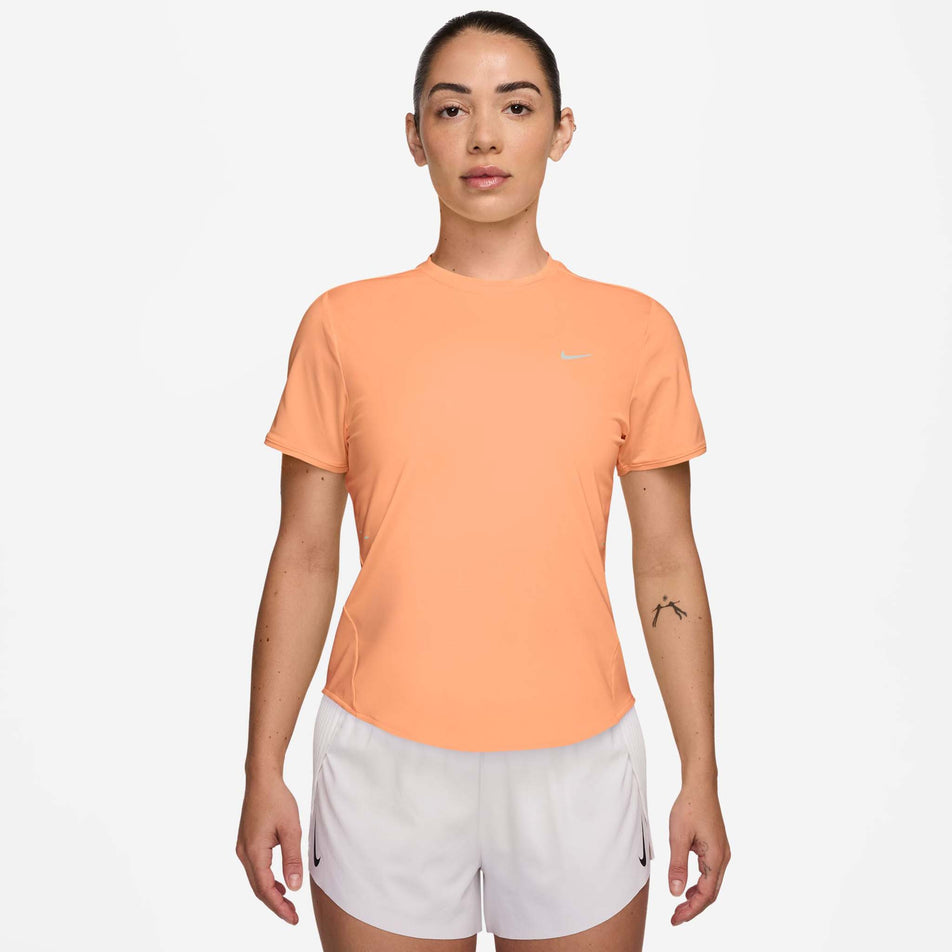 Front view of a model wearing the Nike Women's Swift Dri-FIT Short-Sleeve Running Top in the Orange Pulse/Reflective Silver colourway.