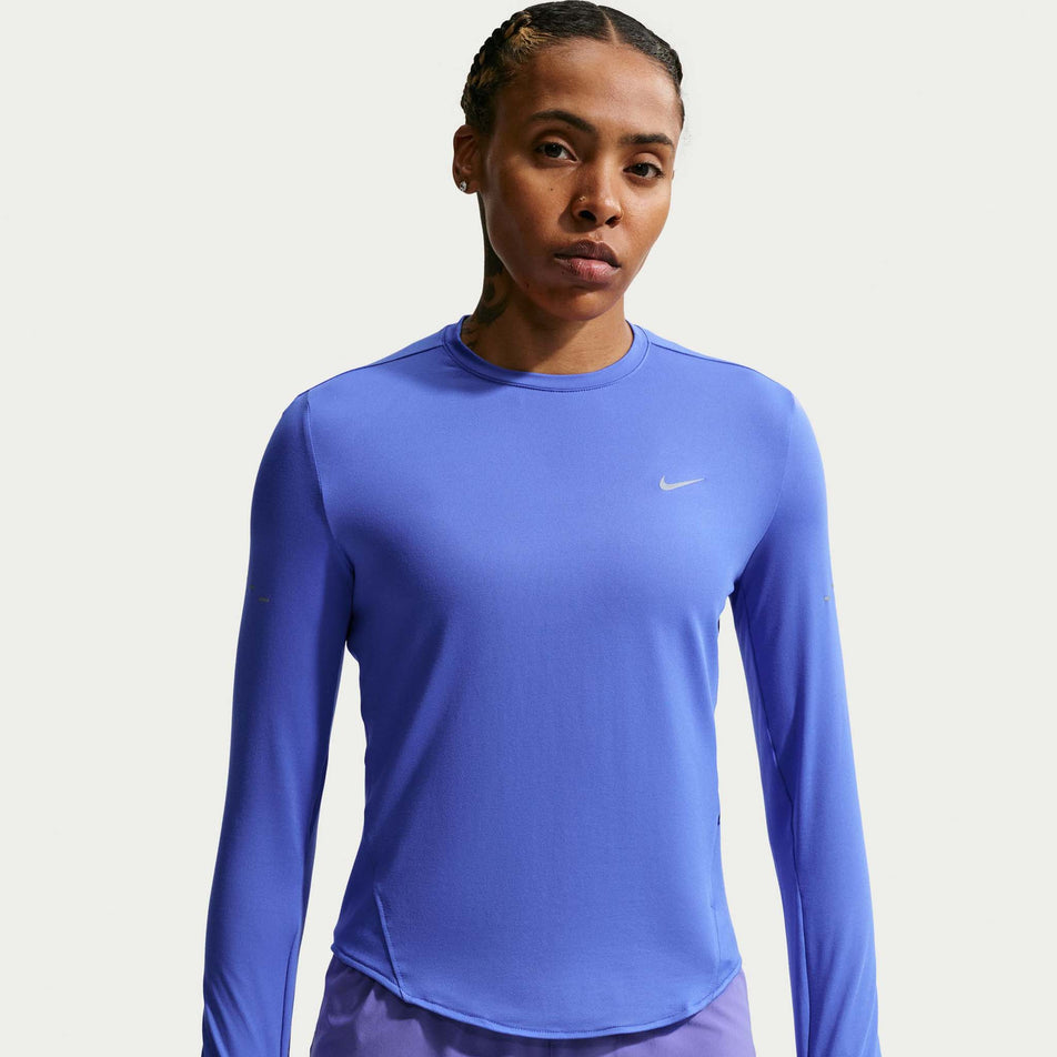 Front view of a model wearing the Nike Women's Swift Dri-FIT UV Long-Sleeve Crew-Neck Running Top in the Sapphire/Reflective Silver colourway.