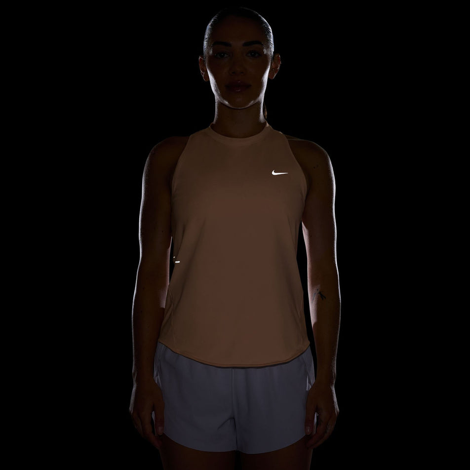 The reflective swoosh on the front of the Nike Women's Swift Dri-FIT Running Tank Top in the Orange Pulse/Reflective Silver colourway.