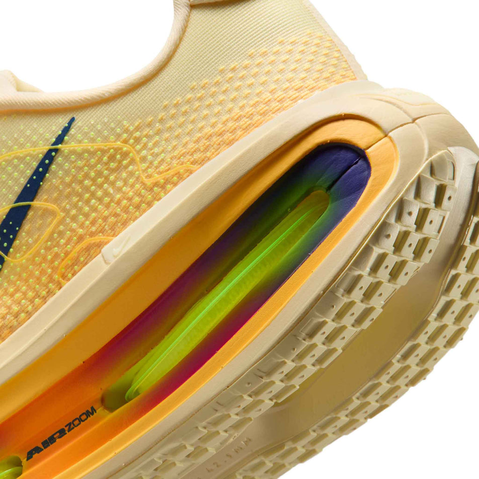 Close-up view of the rearfoot section of the left shoe from a pair of Nike Men's Vomero Premium Road Running Shoes in the Alabaster/Blue Void-Citron Pulse colourway.