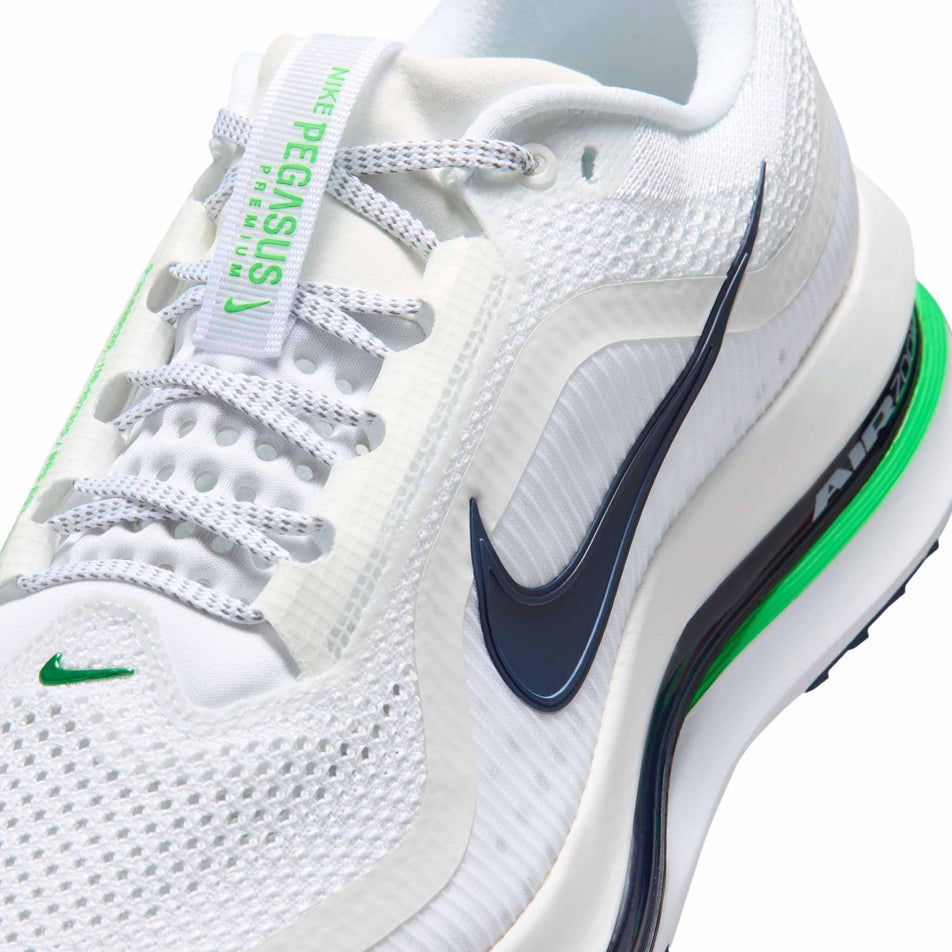 Close-up view of the upper of the left shoe from a pair of Nike Men's Pegasus Premium Road Running Shoes in the White/Green Spark-Midnight Navy colourway.