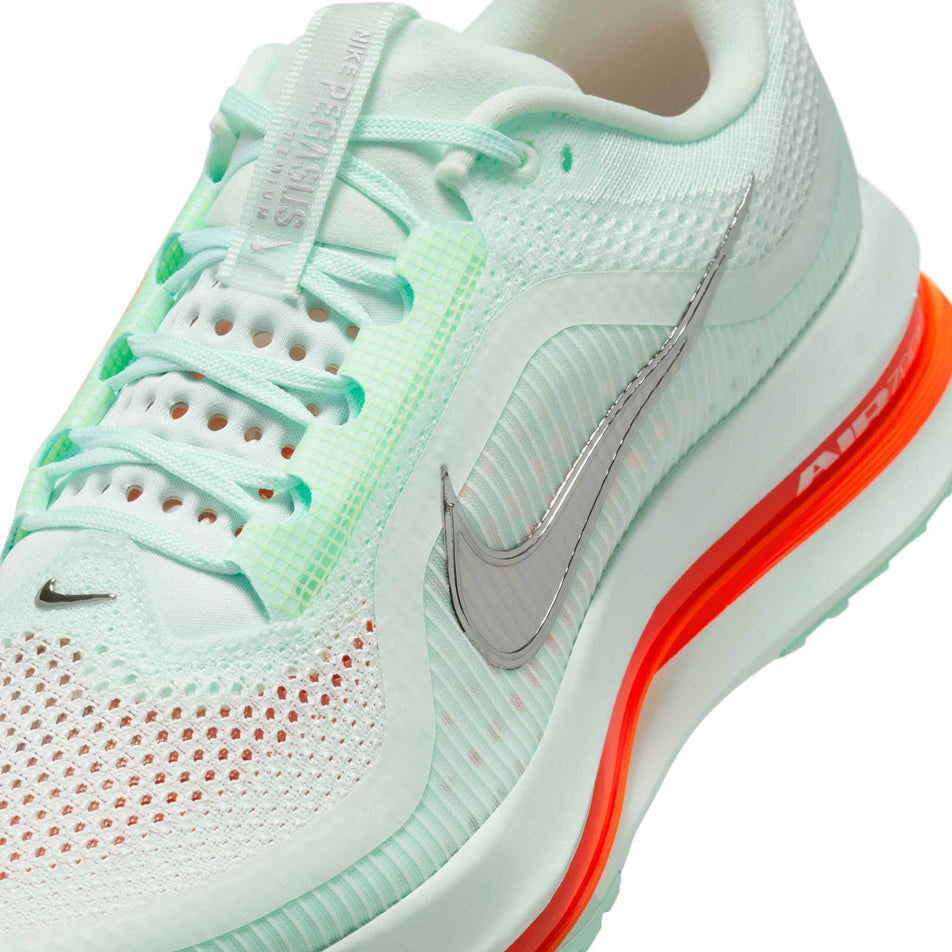 Close up of the upper of the left shoe from a pair of Nike Men's Pegasus Premium Road Running Shoes in the Barely Green/Bright Crimson-Mint Foam colourway. (8683294982306)