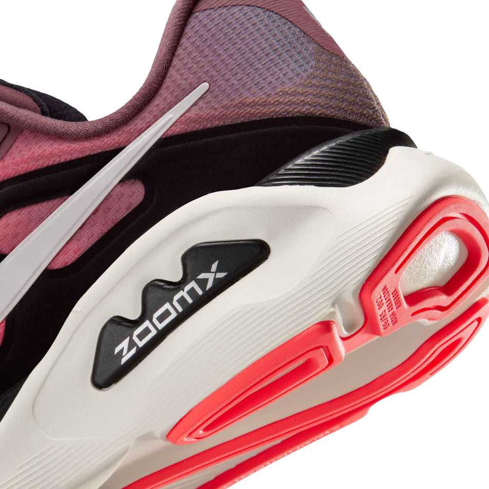 Close-up view of the rearfoot section of the left shoe from a pair of Nike Women's Structure Plus Road Running Shoes in the Tattoo/Silver-Hot Lava-Black colourway.