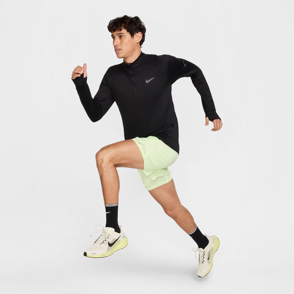 Angled view of a model wearing the Nike Men's Stride Dri-FIT 1/4-Zip Running Top in the Black/Reflective Silver colourway. (8778198876322)