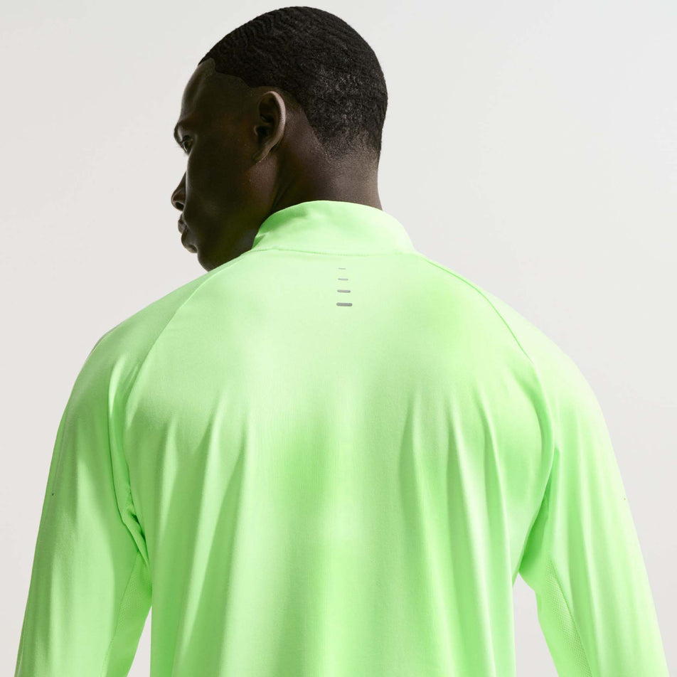 Back view of a model wearing the Nike Men's Stride Dri-FIT 1/4-Zip Running Top in the Lime Blast/Reflective Silver colourway.