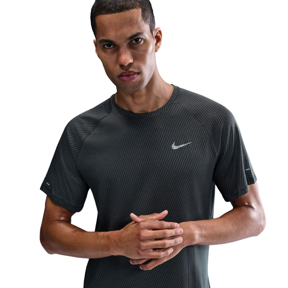 Front view of a model wearing the Nike Men's Dri-FIT Stride Jacquard Short-Sleeve Running Top in the Black/Reflective Silver colourway.  (8716705202338)