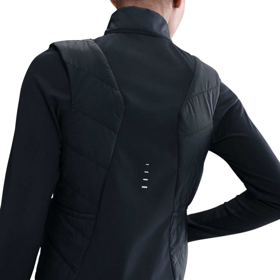 Back view of a model wearing the Nike Women's Swift Therma-FIT Running Vest in the Black/Reflective Silver colourway.