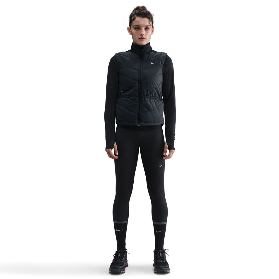 Front view of a model wearing the Nike Women's Swift Therma-FIT Running Vest in the Black/Reflective Silver colourway.