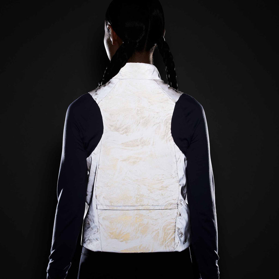 Back view of a model wearing the Nike Women's Therma-FIT ADV Reflective Running Vest in the Vast Grey/Black colourway. (8756535394466)