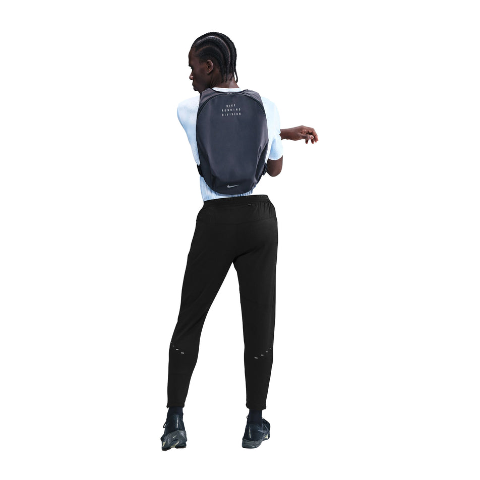 Back view of a model wearing the Nike Men's Dri-FIT Stride Knit Running Pants in the Black/Reflective Silver colourway. (8733229744290)
