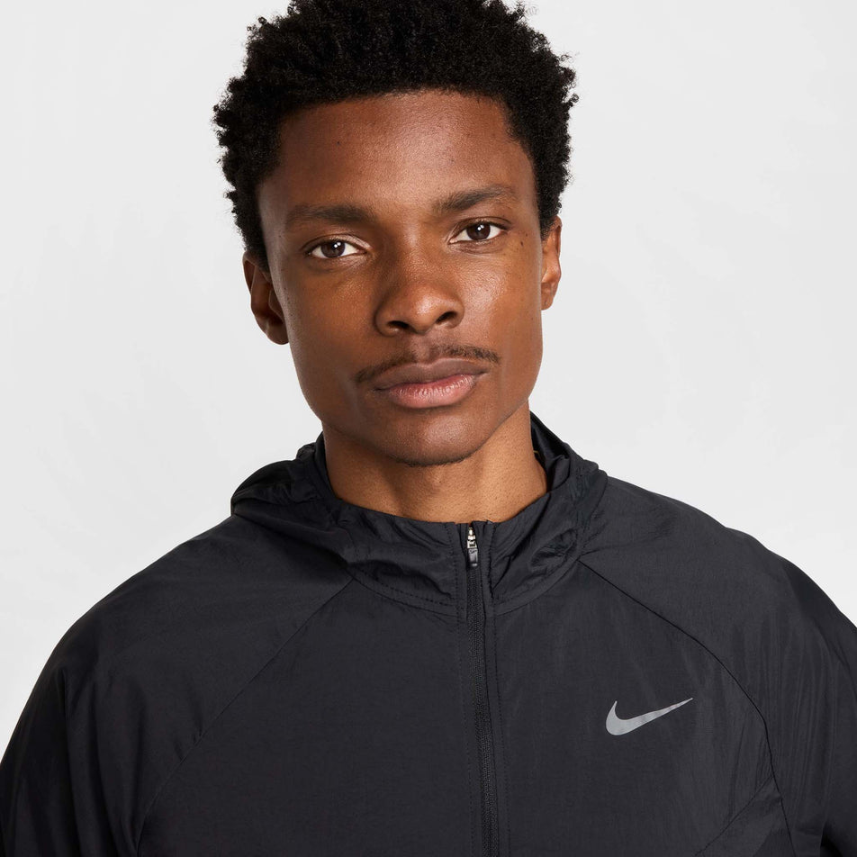 Front view of a model wearing the Nike Men's Stride Repel UV Running Jacket in the Black/Black/Reflective Silver colourway.